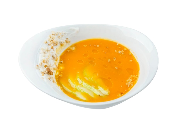 Pumpkin soup puree in a white plate Appetizing traditional autumn dish Top view Isolated on white background