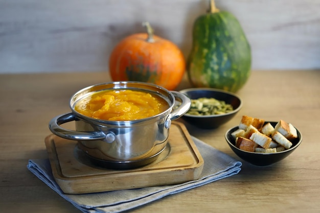 Pumpkin soup in a saucepan with croutons