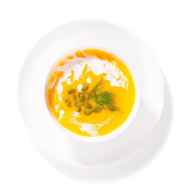 Pumpkin soup in a white plate on a white background isolated