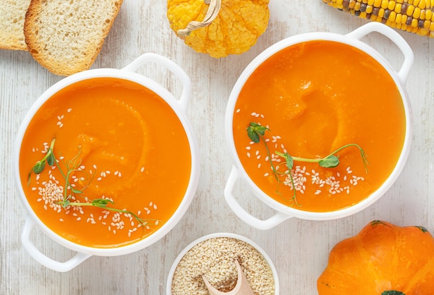 Pumpkin soup with croutons on white wooden background Top view