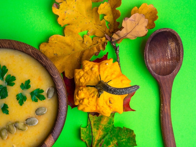 Pumpkin squash vegetable soup with pumpkin seeds parsley in a wooden bowl on green background Pumpkin Squash soup Creamy soup Vegetable soup