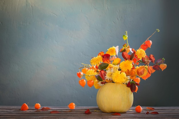 pumpkin with autumnal bouquet on dark background