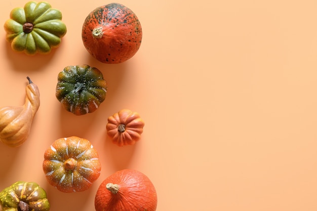 Pumpkins as border on orange background with copy space. Thanksgiving day or Halloween template.