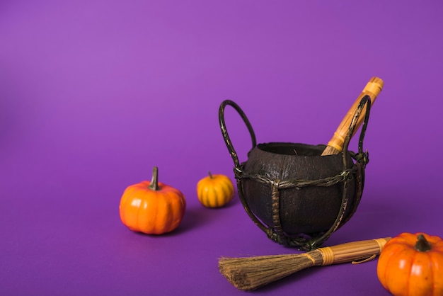 Photo pumpkins and brooms near cauldron