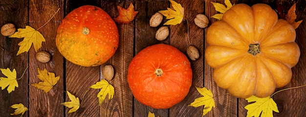 Pumpkins and fallen leaves on white wooden table