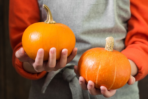 Pumpkins in hand. Autumn composition