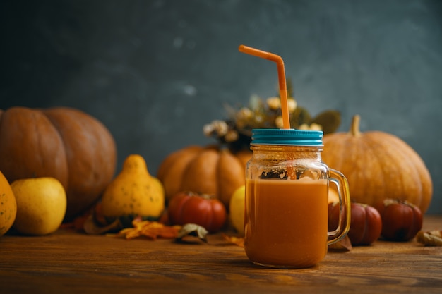 Pumpkins juice in bottles with pumpkins.