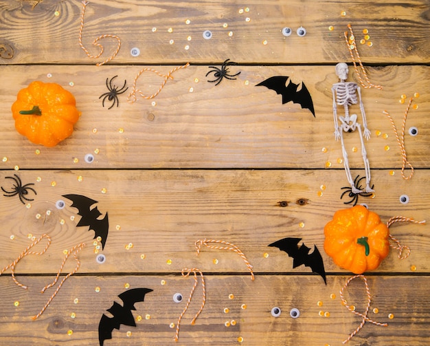 Pumpkins skeletons spiders and bats on a wooden background A festive Halloween theme Empty space for text