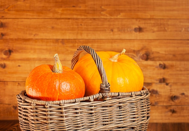 pumpkins in a wicker basket close-up on a wooden background