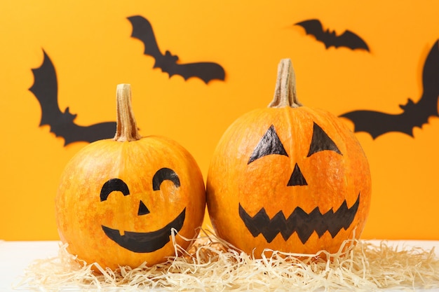 Pumpkins with painted faces on a colored background for halloween