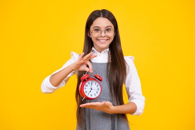 Punctual teen girl checking time Child with alarm clock showing time Happy face positive and smiling emotions of teenager girl