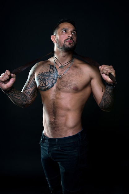 Punishment concept Dominate male Going to punish you Fashion model with leather belt Man with tattoo Bearded man with muscular torso Sportsman with tattooed arm and chest Fitness and sport