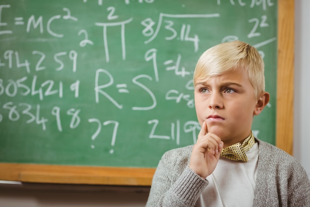 Pupil dressed up as teacher thinking in front of chalkboard