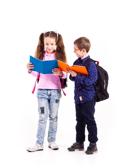 Pupils boy and girl isolated on the white background. Teenagers with backpacks holding books in the hands