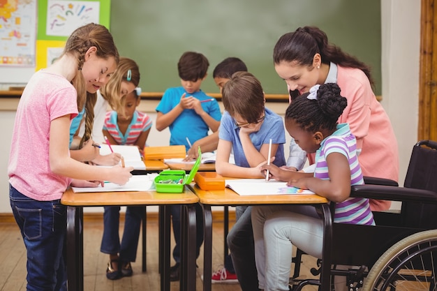 Pupils and teacher working at desk together