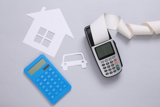 Purchase of property Papercut car and house payment terminal and calculator on a gray background Flat lay