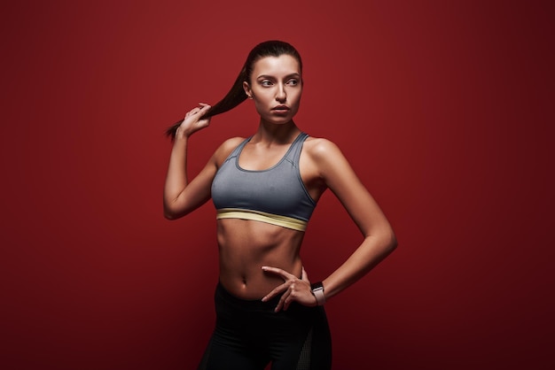 Pure perfection sportswoman standing over red background