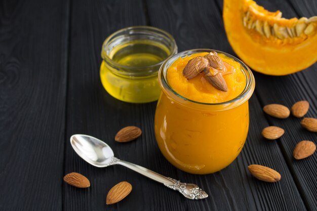 Puree with pumpkin, almonds and honey in glass jar