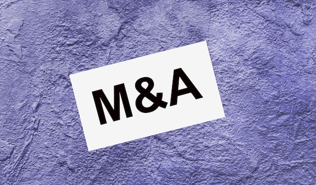 On a purple abstract background there is a white card with the text M AND A