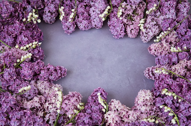 Photo on a purple background lilacs and lilies of the valley are lined with a frame