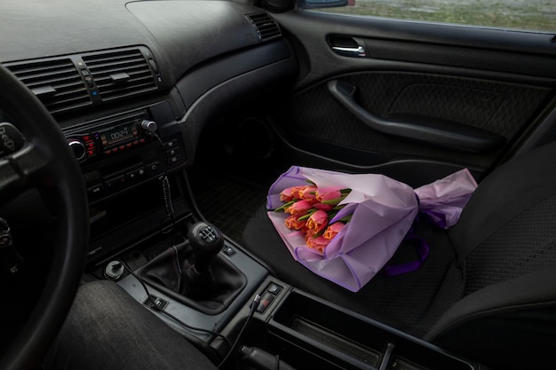 a purple bag of flowers sits in the passenger seat of a car