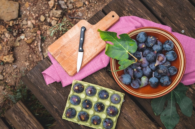 Purple black figs on a rustic wooden picnic table