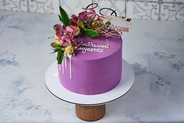 Purple cake for a girl decorated with real flowers Translation quotBeloved mother Happy birthdayquot