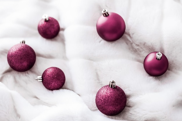 Purple Christmas baubles on white fluffy fur backdrop luxury winter holiday design background