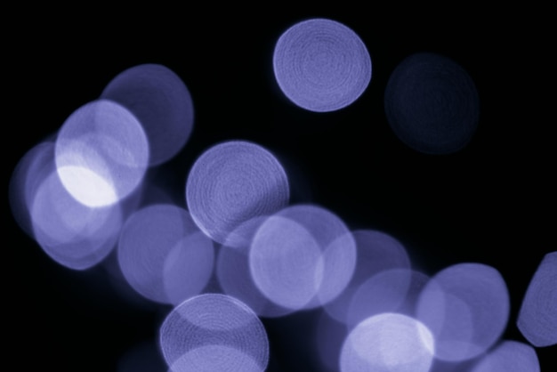 Purple defocused light circle bokeh in very peri color of the year christmas twinkling lights