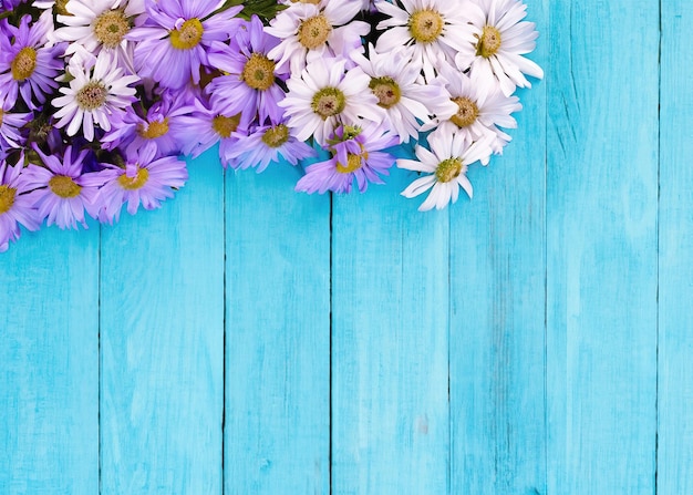 Purple flower on blue wooden background from top view