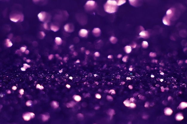 Purple glitter, blurred effect. Glowing holiday light circles are created from bokeh in the camera and lens. Background for design. Christmas background.