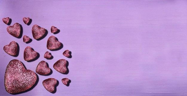 purple glitter hearts on purple background Heart of glitter grains glitter makeup background abst