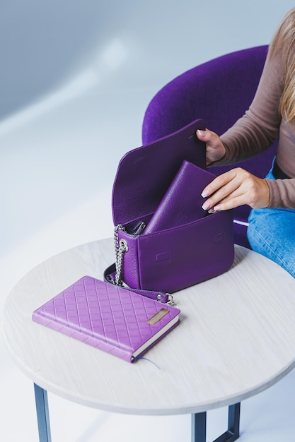 A purple leather bag in a girl's hand Woman with luxury bag