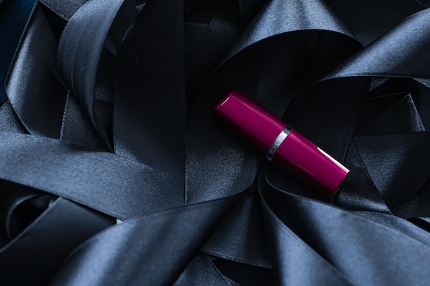 Purple lipstick on black silk background luxury makeup and beauty cosmetic