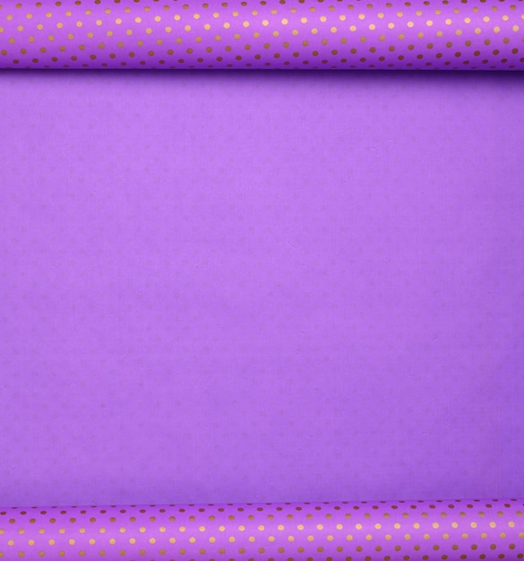 Purple paper bundle in a golden dot deployed, wrapping paper, copy space