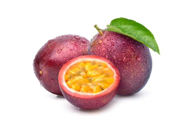 Purple passion fruit with cut in half and green leaf isolated