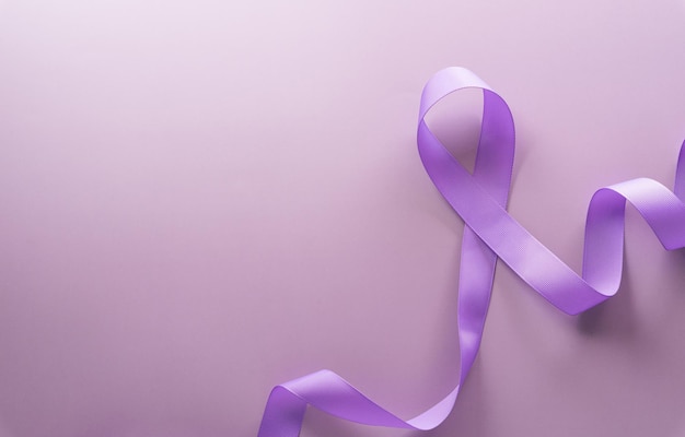 Purple ribbon on pastel paper background for supporting World Cancer Day campaign on February 4