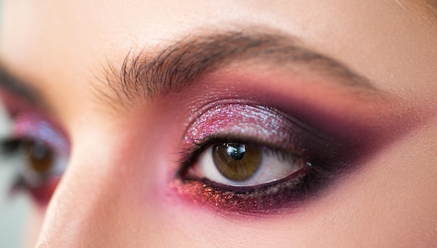 Purple smokey eyes makeup close up photo Professional smokey eyes make up at beautiful girl for special occasion Shiny glitter pigments in eyes make up Luxury eye makeup concept