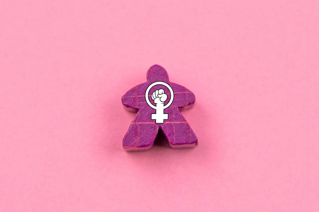 Photo purple wooden doll with the feminist symbol in the center feminism and female empowerment concept march 8 international women39s day