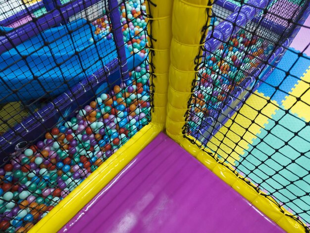 A purple and yellow ball pit with the word ball on it.