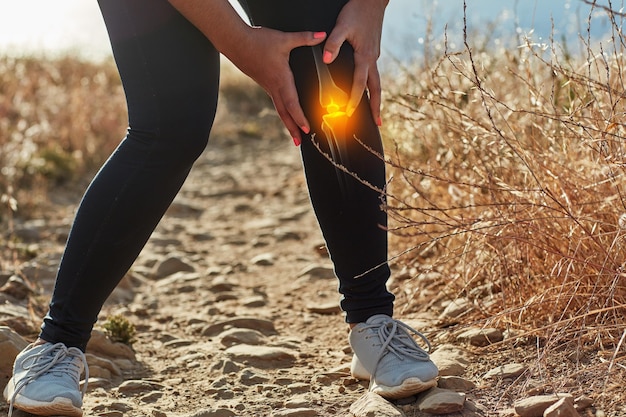 Putting an end to her workout Shot of an unrecognizable woman exercising outdoors with a highlighted knee injury