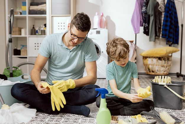 Putting rubber yellow protective gloves on hands cleaning white surface with rag