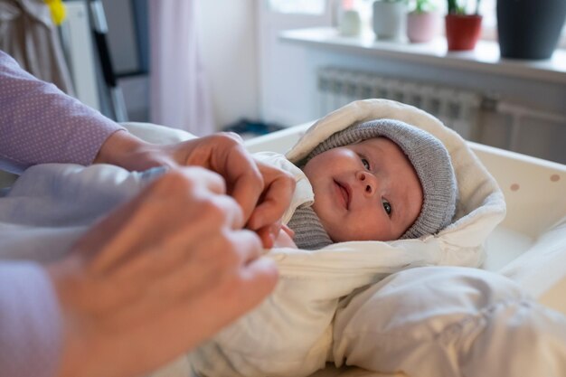 Putting on warm clothes on baby girl preparing for a walk on cold winter day