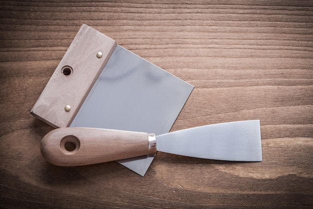 Putty spattle and paint scraper on wood board