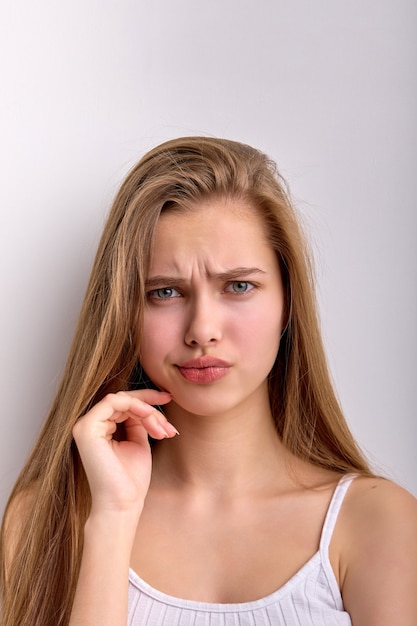 Puzzled perplexed female is dissatisfied with something looking curious isolated on white background...