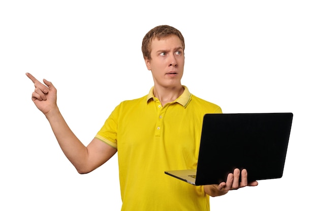 Puzzled young man with laptop pointing with finger isolated on white background male confused face