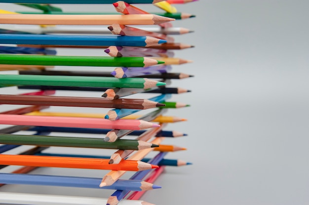 Pyramid of colored pencils on gray