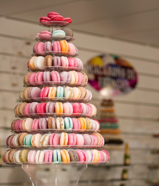 Pyramid of multi-colored macarons on pastel blue background. Delicious and fresh sweeties. Healthy and organic nutrition concept.