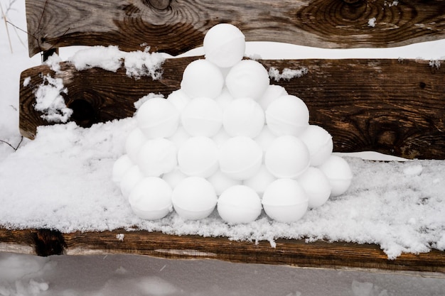 Pyramid or a pile of perfect snowballs on frosty winter day in forest or garden outdoor snowy winter season and fun entertainment in nature