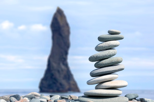 Pyramid of smooth stones against the backdrop of a seascape Rocks Fingers Troll Iceland Waves of the Atlantic ocean